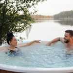 Couple relaxing in a hot tub in the garden, enjoying warm water and bubbles