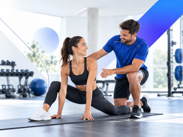 Een personal trainer begeleidt een vrouw tijdens een stretchoefening in een lichte en moderne fitnessstudio.